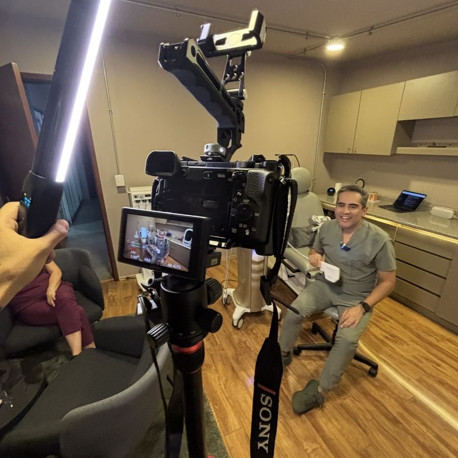 Rodaje de una entrevista con un médico en su consultorio, con cámara y luz de tubo en primer plano